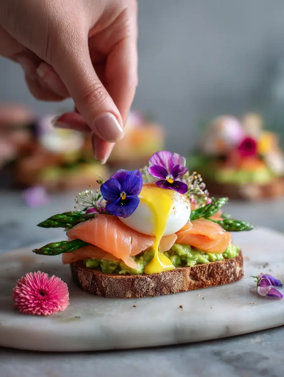 Assembling smoked salmon avocado toast with hollandaise drizzle.