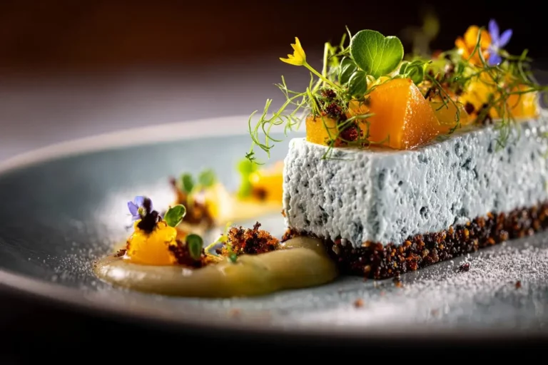 Blue Cheese Mousse Log with pear compote, rye crumb, and thyme dust on marble plate.